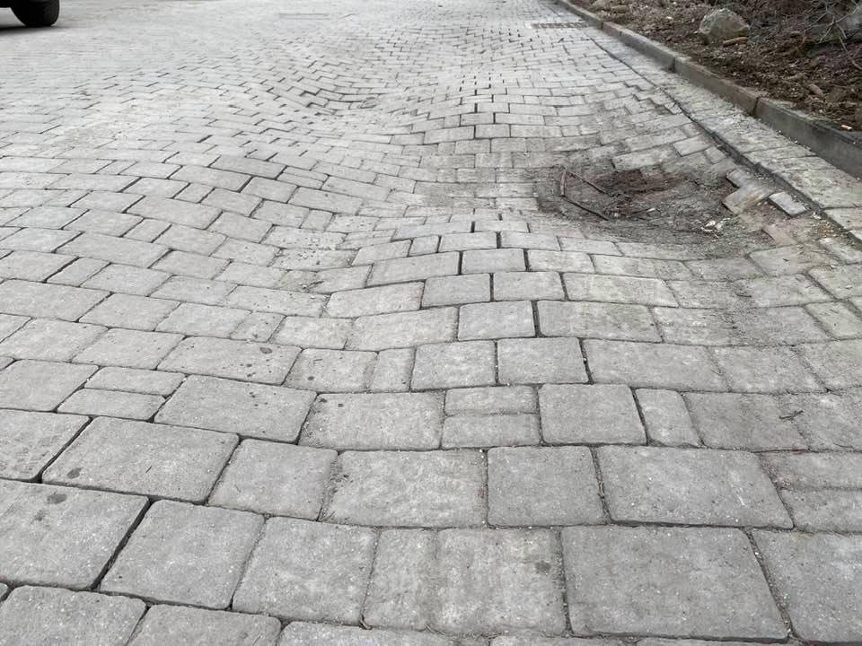Exposed bedding material and base underneath outdoor pavers